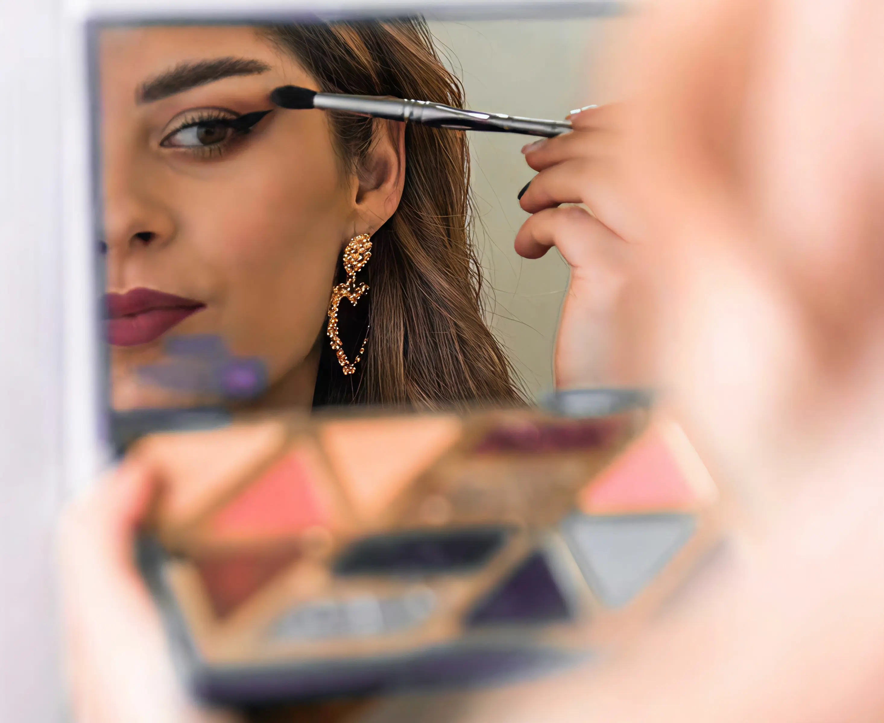 Reflexie artistică a makeup artistei în paleta de machiaj, simbol pentru cursul de automachiaj