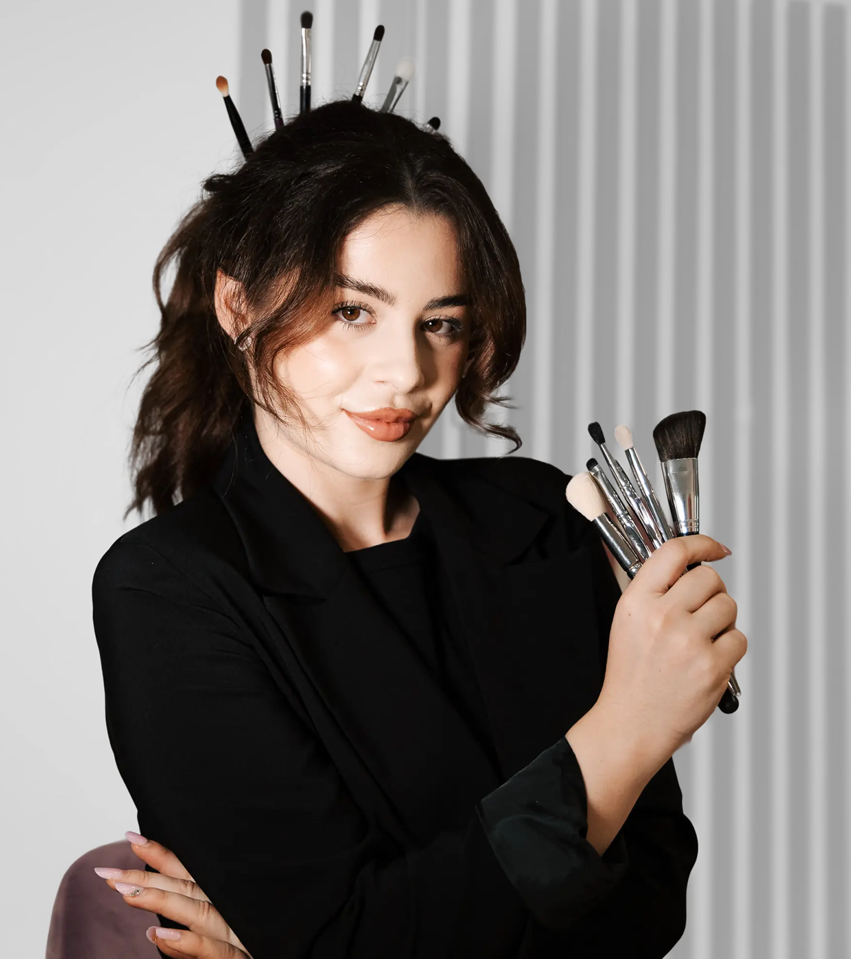 Autoportret artistic al makeup artistei, cu pensule în mână și în păr, simbol al pasiunii și profesionalismului